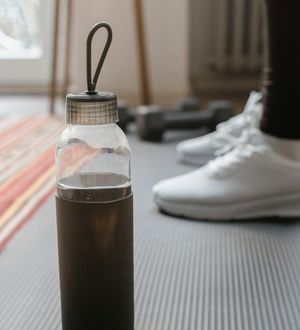 Close-up of exercise equipment like a yoga mat and a water bottle.